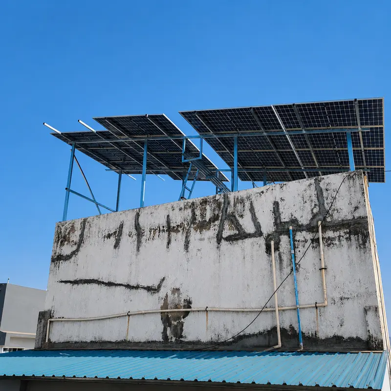 Solar modules on a blue raised steel structure above a residential rooftop parapet